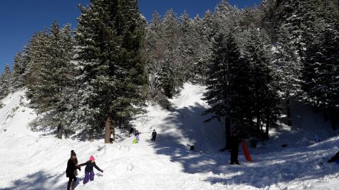Visitors gather at a sledding hill in the aftermath of a snow storm Friday, Feb. 22, 2019, in Wrightwood, Calif. A winter storm swept through the Southwest and brought a rare snowfall to the Las Vegas Strip and the mountains above Malibu in California. (AP Photo/Marcio Jose Sanchez)