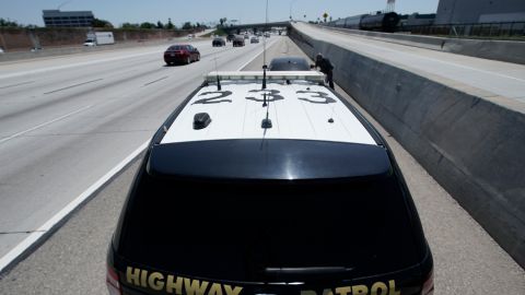 California Highway Patrol officer, Matthew Musselmann stops a motorist on Interstate 5 freeway who is suspected of speeding on Interstate 5 freeway for speeding Thursday, April 23, 2020, in Anaheim, Calif. The CHP is issuing a lot more tickets to motorists where lanes are wide open during the coronavirus pandemic. From March 19, when the stay-at-home order began, through April 19, officers issued 87% more citations to drivers suspected of speeding in excess of 100 mph. That's compared to the same period last year. The jump in speeding tickets coincides with a 35% decline in traffic volume. (AP Photo/Chris Carlson)