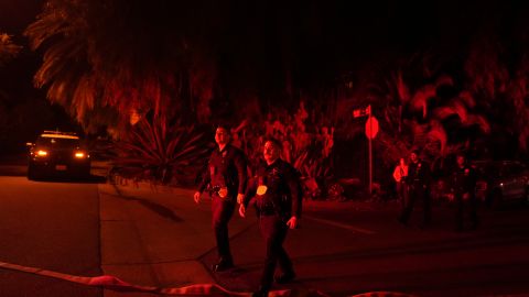 Police officers check on homes to evacuate residents near the Palisades Fire in Mandeville Canyon, Friday, Jan. 10, 2025, in Los Angeles. (AP Photo/Eric Thayer)