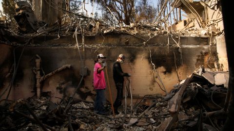 Kaegan Baron, left, and Oliver Braren sift through the home of Kaegan's mother after it was destroyed by the Palisades Fire in the Pacific Palisades neighborhood of Los Angeles, Saturday, Jan. 11, 2025. (AP Photo/John Locher)