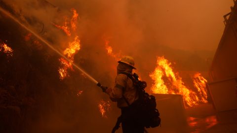 A firefighter battles the advancing Palisades Fire around a structure in the Pacific Palisades neighborhood of Los Angeles Tuesday, Jan. 7, 2025. (AP Photo/Etienne Laurent)