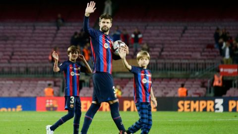 Gerard Piqué, del Barcelona, y sus hijos Milan y Sasha saludan a los aficionados al final del partido de la Liga Española entre el Barcelona y el Almería en el estadio Camp Nou de Barcelona, España, el sábado 5 de noviembre de 2022. Piqué jugó el último partido de su carrera profesional como local. (Foto AP/Joan Monfort)