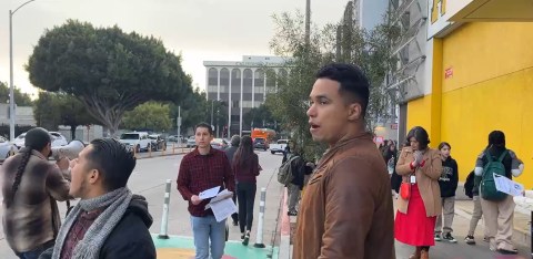 Maestros y activistas entregan una tarjeta roja con los derechos de los migrantes.