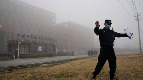 Un guardia aleja a periodistas del Instituto de Virología de Wuhan después de que un equipo de la OMS llegara para una visita el 3 de febrero de 2021.