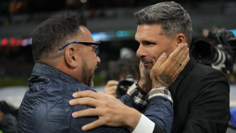 Pumas' coach Antonio Mohamed, left, greats America's coach Fernando Ortiz prior to a Mexican soccer league match at Azteca stadium in Mexico City, Saturday, April 22, 2023. (AP Photo/Moises Castillo)