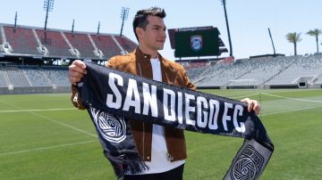 Hirving "Chucky" Lozano poses with a San Diego FC scarf during an introductory news conference for the new MLS soccer team, Thursday, June 13, 2024, in San Diego. The Mexican star will be part of San Diego FC's first season, when they join the MLS in 2025. (AP Photo/Gregory Bull)