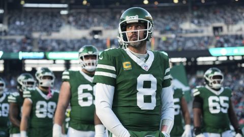 New York Jets quarterback Aaron Rodgers (8) stands with teammates before an NFL football game against the Miami Dolphins, Sunday, Jan. 5, 2025, in East Rutherford, N.J. (AP Photo/Seth Wenig)