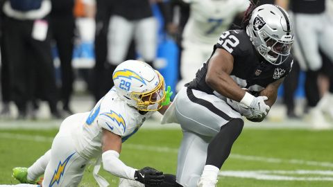 El corredor de los Raiders de Las Vegas, Alexander Mattison (22), corre contra el esquinero de los Chargers de Los Ángeles, Tarheeb Still (29), durante la primera mitad de un partido de fútbol americano de la NFL en Las Vegas, el domingo 5 de enero de 2025.