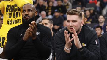 LeBron James y Luka Doncic, de los Lakers de Los Ángeles, se sientan juntos durante el partido ante los Clippers de la misma ciudad, el martes 4 de febrero de 2025 (AP Foto/Kevork Djansezian)