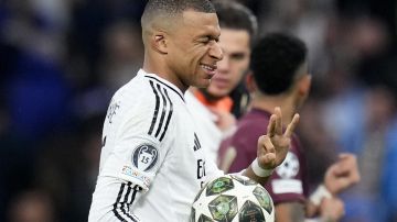 Real Madrid's Kylian Mbappe gestures as he leaves the pitch with the match ball after scoring a hat trick, at the end of the Champions League playoff second leg soccer match between Real Madrid and Manchester City at the Santiago Bernabeu Stadium in Madrid, Spain, Wednesday, Feb. 19, 2025. (AP Photo/Manu Fernandez)