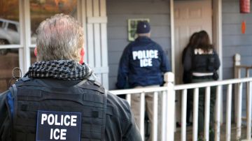 FILE - In this Feb. 9, 2017, file photo provided by U.S. Immigration and Customs Enforcement, ICE agents stand outside a home in Atlanta during a targeted enforcement operation aimed at immigration fugitives, re-entrants and at-large criminals living in the country illegally. With seven Georgia Republicans jockeying for their party’s nomination, illegal immigration is one thing that the leading candidates are largely in agreement on: the state may have some of the toughest laws targeting illegal immigration in the country, but it needs to do more, they say. (Bryan Cox/ICE via AP, File)