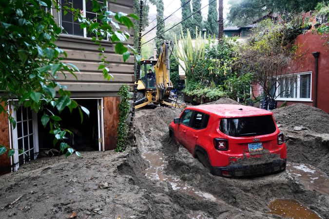 A vehicle is dug out of the mud after a storm Friday, Feb. 14, 2025, in Sierra Madre, Calif. (AP Photo/Damian Dovarganes)