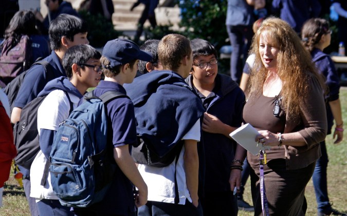 Teacher Colleen Schwab talks with students on the campus of Woodland Hills Academy, a charter middle school in the Woodland Hills area of Los Angeles on Oct. 26, 2010. Independent charter schools run by teacher groups have been around for several decades, but a new teacher-led model is emerging on a wider scale that gives teachers more power and schools more autonomy. Some, like Woodland Hills, retain principals but reduce their authority; some eschew principals altogether. (AP Photo/Reed Saxon)