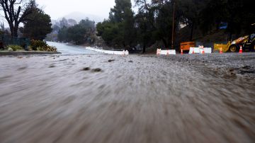 Mud flows down a road in the Eaton Fire zone during a storm Thursday, Feb. 13, 2025, in Altadena, Calif. (AP Photo/Etienne Laurent)