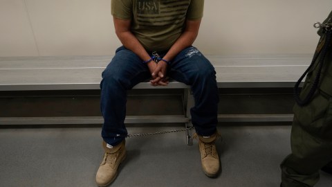 FILE - An immigrant considered a threat to public safety and national security waits to be processed by U.S. Immigration and Customs Enforcement agents at the ICE Metropolitan Detention Center in Los Angeles, after an early morning raid, June 6, 2022. (AP Photo/Damian Dovarganes, File)