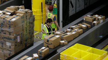 FILE - In this Feb. 9, 2018, file photo packages move down a conveyor system were they are directed to the proper shipping area at the new Amazon Fulfillment Center in Sacramento, Calif. Amazon said Monday, Sept. 14, 2020, that it will be hiring another 100,000 people to keep up with a surge of online orders. The company said the new hires will help pack, ship or sort orders, working in part-time and full-time roles. Amazon said the jobs are not related to its typical holiday hiring. (AP Photo/Rich Pedroncelli, File)