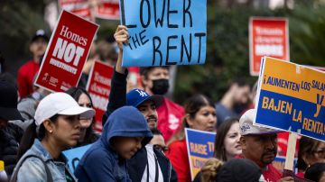 A protester holds a poster reading "Lower the Rent" as demonstrators gather for a march to demand better wages and lower rent prices in Los Angeles, Saturday, Sept. 28, 2024. (AP Photo/Etienne Laurent)