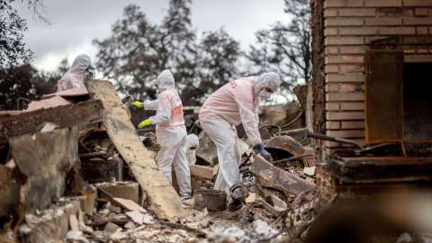 Volunteers from Samaritan's Purse help search a home for items that survived the Eaton Fire, Thursday, Feb. 6, 2025, in Altadena, Calif. (AP Photo/Ethan Swope)