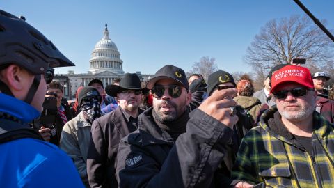 El exlíder de Proud Boys, Enrique Tarrio, en el centro, habla con un oficial de la Policía del Capitolio de Estados Unidos.