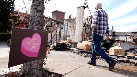 A pedestrian walks by a property destroyed by the Eaton Fire, Monday, Feb. 17, 2025, in in Altadena, Calif. (AP Photo/Chris Pizzello)