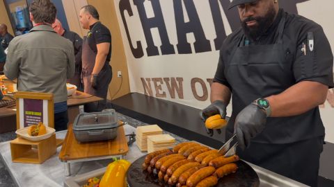 El hot dog de salchicha de caimán se sirve con salsa de guiso de mariscos en pan francés y con papas chips de acompañamiento.