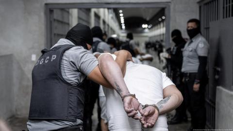 Policías salvadoreños trasladan a presuntos miembros del Tren de Aragua recién llegados al país centroamericano desde Estados Unidos.