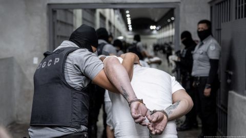 Policías salvadoreños trasladan a presuntos miembros del Tren de Aragua recién llegados al país centroamericano desde Estados Unidos.