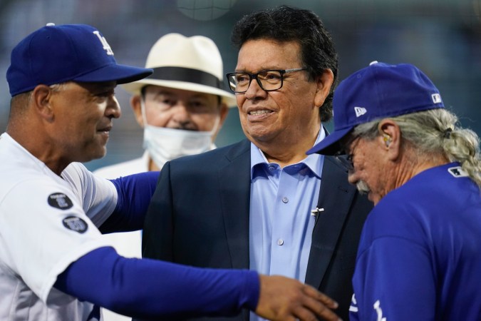 Dave Roberts (izq.) felicita a Fernando Valenzuela (centro) durante una ceremonia en honor al legendario pitcher mexicano el 15 de septiembre de 2021 en Los Ángeles. El manager de los Dodgers dice que aprendió humildad de Valenzuela. Los acompañan Mike Brito y Edward James Olmos.
