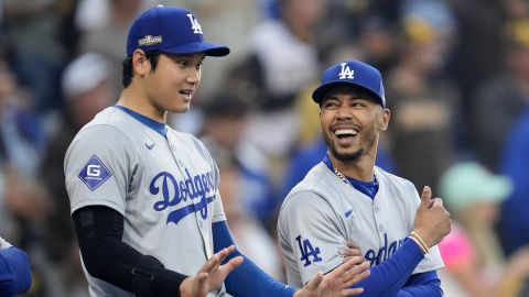 Los Angeles Dodgers' Shohei Ohtani, left, talks to Mookie Betts before Game 3 of a baseball NL Division Series against the San Diego Padres, Tuesday, Oct. 8, 2024, in San Diego. (AP Photo/Ashley Landis)