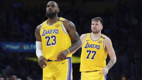 Los Angeles Lakers' LeBron James (23) and Luka Doncic (77) watch action during the second half of an NBA basketball game against the New Orleans Pelicans Tuesday, March 4, 2025, in Los Angeles. (AP Photo/Jae C. Hong)