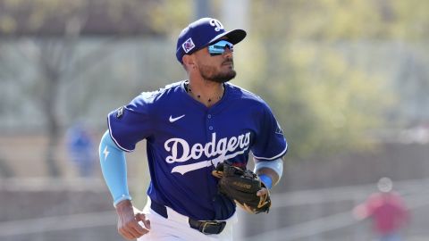 Los Angeles Dodgers second baseman Miguel Rojas runs back to the dugout after the Texas Rangers are retired during the first inning of a spring training baseball game Thursday, March 6, 2025, in Phoenix. (AP Photo/Ross D. Franklin)