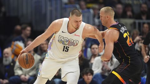 Denver Nuggets center Nikola Jokic, left, drives to the basket as Phoenix Suns center Mason Plumlee defends in the second half of an NBA basketball game Friday, March 7, 2025, in Denver. (AP Photo/David Zalubowski)