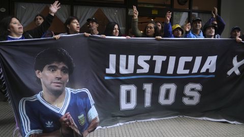 Fans de Maradona sostienen una manta afuera del tribunal.