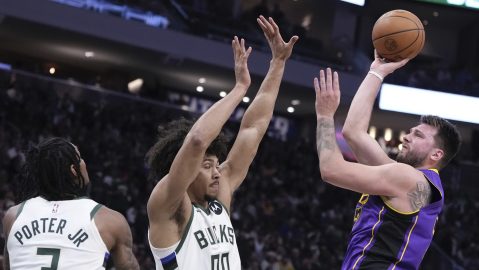 Los Angeles Lakers' Luka Doncic shoots past Milwaukee Bucks' Kevin Porter Jr. and Jericho Sims during the first half of an NBA basketball game Thursday, Mar. 13, 2025, in Milwaukee. (AP Photo/Morry Gash)