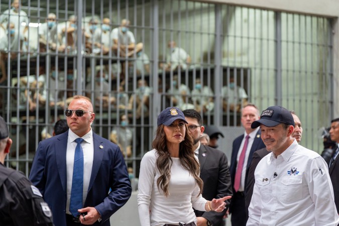 El ministro de Justicia y Seguridad Pública, Héctor Villatoro, a la derecha, acompaña a la secretaria de Seguridad Nacional, Kristi Noem, al centro, durante un recorrido por CECOT.