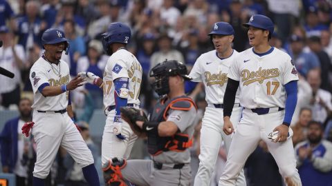 Teoscar Hernández es felicitado por Mookie Betts (izq.) luego de batear un jonrón de tres carreras que puso arriba a los Dodgers contra Detroit en su juego inaugural en Los Ángeles. Atestiguan Freedie Freeman y Shohei Ohtani.