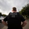 FILE - In this July 8, 2019, file photo, a U.S. Immigration and Customs Enforcement (ICE) officer looks on during an operation in Escondido, Calif. Advocacy groups and unions are pressuring Marriott, MGM and others not to house migrants who have been arrested by U.S. Immigration and Customs Enforcement agents. But the U.S. government says it sometimes needs bed space, and if hotels don’t help it might have to split up families. (AP Photo/Gregory Bull, File)