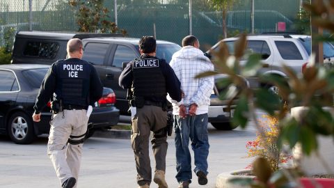 FILE - In this March 30, 2012, file photo, Immigration and Customs Enforcement agents take a suspect into custody as part of a nationwide immigration sweep in Chula Vista, Calif. A report issued Tuesday, May 8, 2018, by the nonpartisan Migration Policy Institute suggests that pushback from California and some cities is slowing the transfer of inmates into immigration custody despite the Trump administration stepping up immigration arrests overall. (AP Photo/Gregory Bull, File)