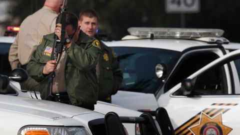 A San Bernardino County sheriff's deputy stands guard near the area where a shooting took place in Riverside, Calif, Thursday, Feb. 7, 2013. Police launched a massive manhunt for a former Los Angeles officer suspected of going on a killing spree, slaying a couple over the weekend, opening fire on two Los Angeles officers early Thursday and then ambushing two other police officers, killing one. (AP Photo/Jae C. Hong)