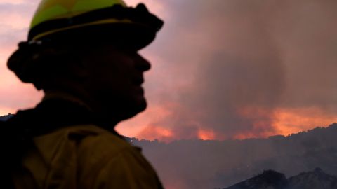 A firefighter keeps watch as smoke rises from a brush fire scorching at least 100 acres in the Pacific Palisades area of Los Angeles on Saturday, May 15, 2021. (AP Photo/Ringo H.W. Chiu)