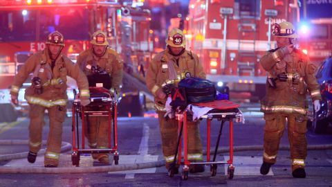 FILE - Los Angeles Fire Department firefighters push gurneys at the scene of a structure fire that injured multiple firefighters, May 16, 2020. The owner of a downtown Los Angeles building where an explosion injured 12 firefighters has been allowed to enter a judicial diversion program that allows him to avoid jail time. A court commissioner on Wednesday, March 30, 2022, granted Steve Sungho Lee's request to enter the two-year program. (AP Photo/Damian Dovarganes, File)