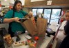 Cashier Denise Cruz checks out customers' purchases at a hardware store in Los Angeles Tuesday, Oct. 4, 2011. Service firms that employ 90 percent of the U.S. work force grew at a slower pace in September, evidence that the economy is growing but at a sluggish pace. (AP Photo/Reed Saxon)