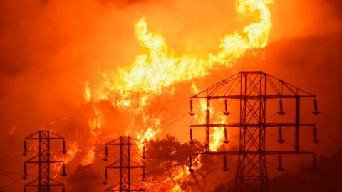 FILE - In this Dec. 16, 2017, file photo provided by the Santa Barbara County Fire Department, flames burn near power lines in Sycamore Canyon near West Mountain Drive in Montecito, Calif. An investigation has determined that one of the largest and most destructive fires in California history was sparked by power lines coming into contact during high winds. The Ventura County Fire Department says Wednesday, March 13, 2019, that Southern California Edison power lines contact ignited dry brush on Dec. 4, 2017 and eventually blackened more than 440 square miles (1,139 square kilometers). (Mike Eliason/Santa Barbara County Fire Department via AP, File)
