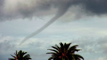 FILE - In this Tuesday, Feb. 22, 2005 file photo, a funnel cloud is seen over the Pacific Ocean off Venice Beach in Los Angeles. On Tuesday, Jan. 10, 2017, a twister touched down south of the state capital and registered EF0, at the lowest edge of the tornado scale that goes up to EF5. The Enhanced Fujita (EF) scale measures the intensity of tornadoes in the U.S. and Canada based on damage caused. (AP Photo/Chris Kim, File)