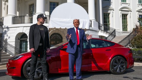 El presidente Donald Trump y el director ejecutivo de Tesla, Elon Musk, hablan con los periodistas frente a un Tesla Model S rojo.