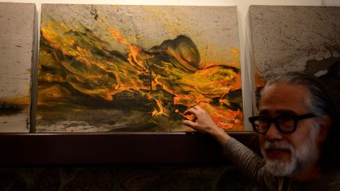 Alejandro M. Lopez enseña una pintura que hizo relacionado al incendio Eaton en Altadena.