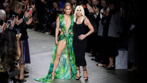 Actress Jennifer Lopez, left, and designer Donatella Versace accept applause at the conclusion of the Versace Spring-Summer 2020 collection, unveiled during the fashion week, in Milan, Italy, Friday, Sept. 20, 2019. (AP Photo/Luca Bruno, File)