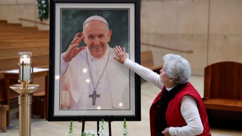 Una persona se acerca para tocar un retrato del papa Francisco después de una misa en su honor en la Catedral de Nuestra Señora de los Ángeles.