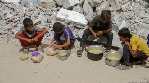 Menores de Gaza reciben comida de organizaciones de caridad.