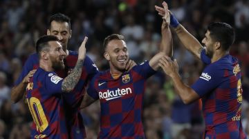 Barcelona's Arthur, centre, celebrates with Lionel Messi, left and Barcelona's Luis Suarez after scoring his side's second goal during the Spanish La Liga soccer match between FC Barcelona and Villarreal CF at the Camp Nou stadium in Barcelona, Spain, Tuesday, Sep. 24, 2019. (AP Photo/Joan Monfort)
